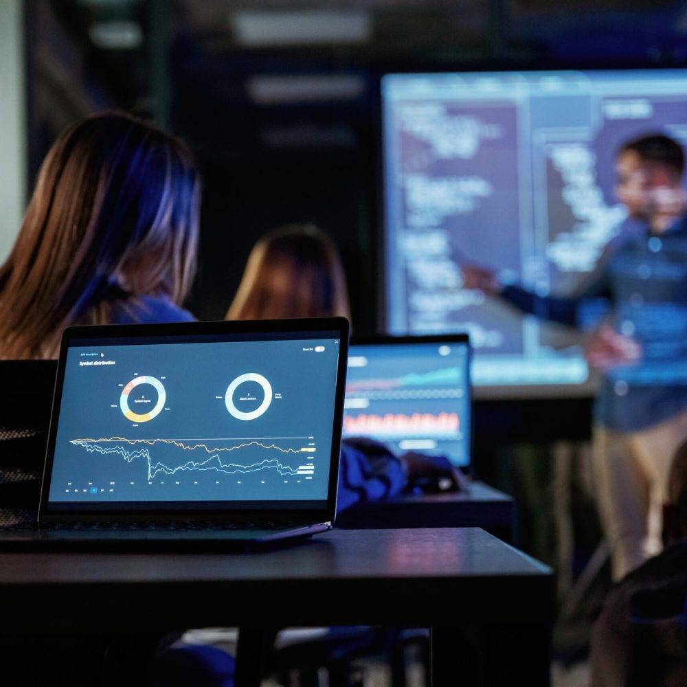 Talking about project. Male business trainer is against projector with data, teaching people.